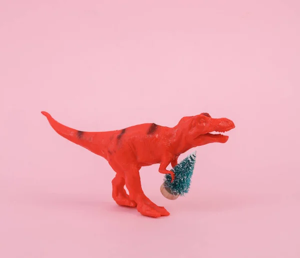 Spielzeug Dinosaurier Tyrannosaurus Rex Mit Weihnachtsbaum Auf Rosa Hintergrund Minimalismus — Stockfoto