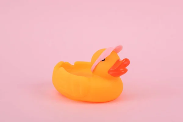 Rubber duck in a cap on a pink background. Creative summer layout