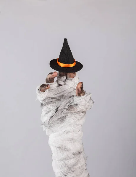 黒い背景に魔女の帽子が隔離された包帯に包まれたママの手 ハロウィンのコンセプト — ストック写真