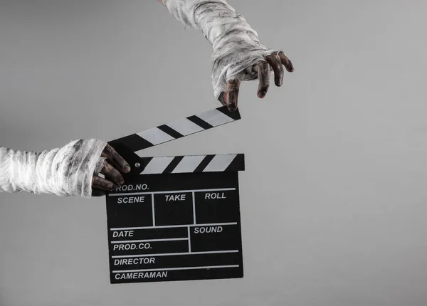 Mummy Hands Wrapped Bandage Holds Movie Clapperboard Isolated Gray Background — Stock Photo, Image