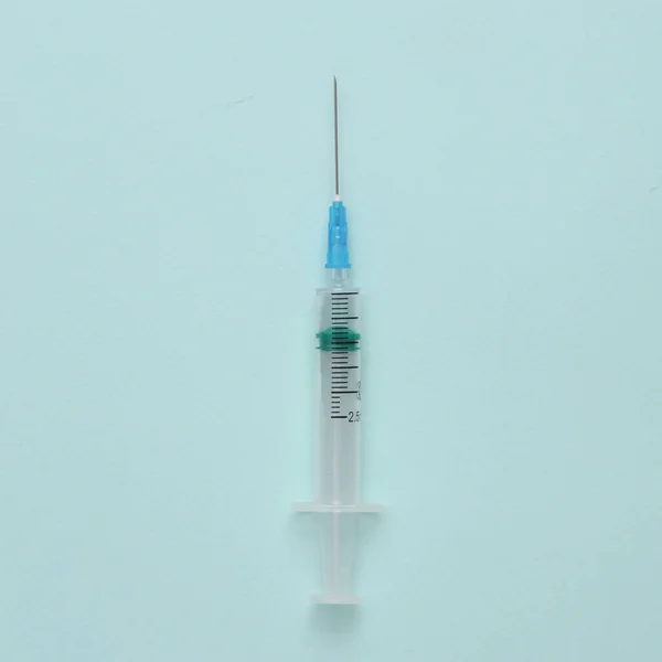 青い背景に針をつけた注射器 — ストック写真