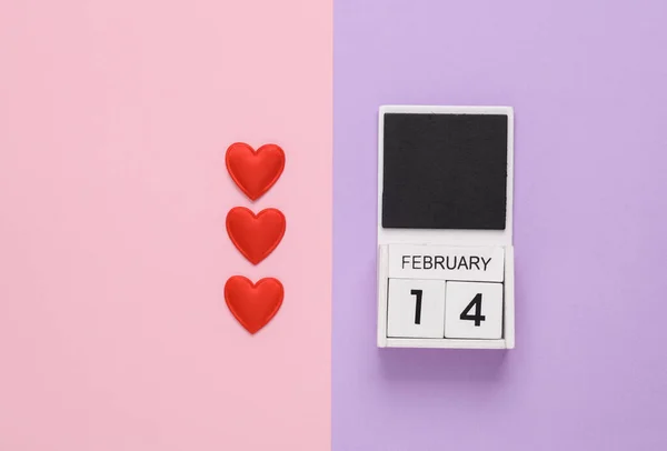 February 14 wooden calendar with hearts on pastel background. Valentine\'s Day