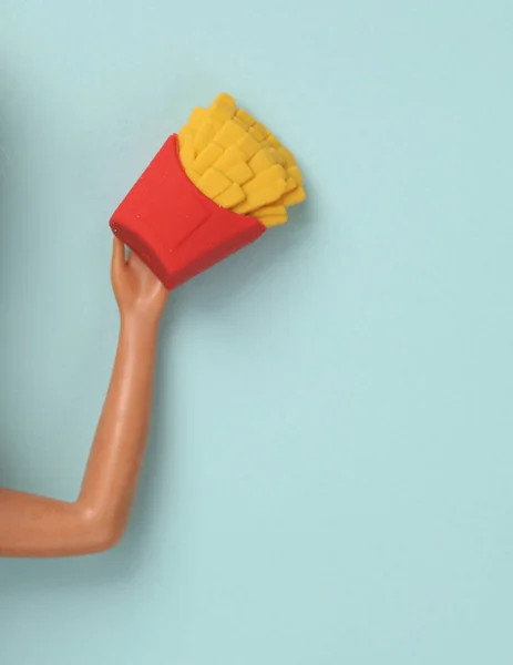 Dłoń Lalki Miniaturą Frytek Niebieskim Tle Fast Food Śmieciowe Jedzenie — Zdjęcie stockowe