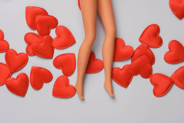 Doll legs with hearts on gray background. Love, romance, valentine\'s day, February 14 concept