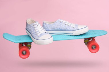 Pembe arka planda gölgesi olan spor ayakkabılı genç plastik para tahtası.