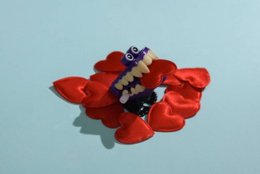 Pembe arka planda kalpleri olan bir canavar. Aşk konsepti, Sevgililer Günü, 14 Şubat kutlamaları, yaratıcı düzen.