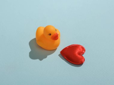 Mavi arka planda kalbi olan plastik ördek. Aşk konsepti, Sevgililer Günü, 14 Şubat kutlamaları, yaratıcı düzen.