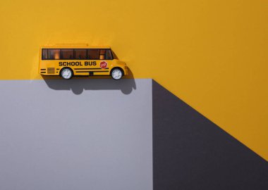 Oyuncak okul otobüsü kağıt küpün üzerinde. Optik yanılsama. Geometrik bileşim. Asgari yaratıcı yerleşim