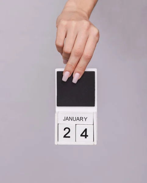 Mano Femenina Sosteniendo Calendario Madera Con Fecha Enero Sobre Fondo — Foto de Stock