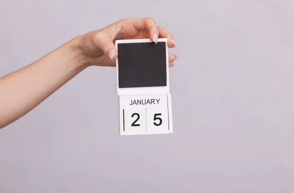 stock image Female hand holding wooden calendar with date January 25 on gray background
