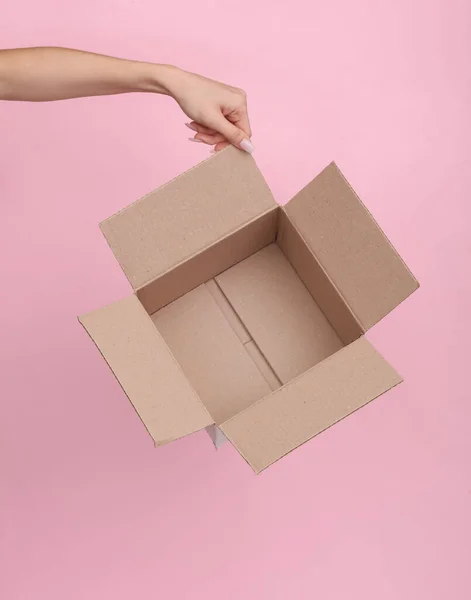 粉红底色的女性手中的空纸盒 — 图库照片