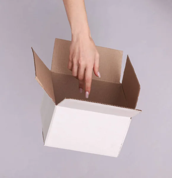Offene Pappschachtel Und Weibliche Hand Auf Grauem Hintergrund — Stockfoto