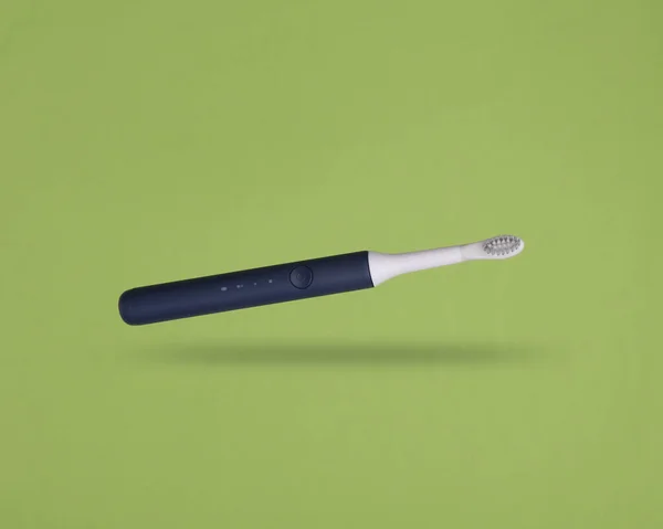 Ultraschall Zahnbürste Schwebt Auf Grünem Hintergrund — Stockfoto
