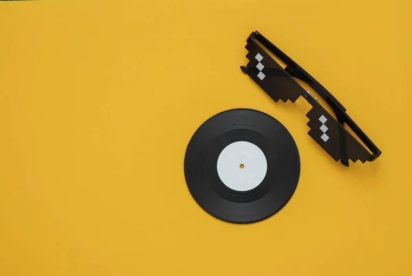 黄色の背景にビニールレコードとステレオヘッドフォン 音楽の概念 — ストック写真