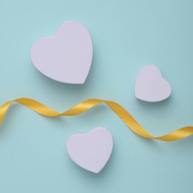 Mavi arka planda saten kurdeleli kupa şeklinde hediye kutuları. Sevgililer Günü. Üst görünüm