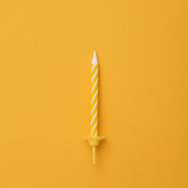 Sarı arka planda doğum günü kutlaması mumu