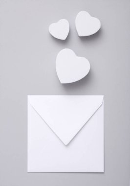 Gri arka planda kalpleri olan beyaz zarf.