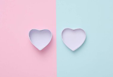 Pembe mavi arka planda boş kalp şeklinde bir kutu.