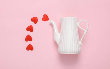 Pembe arka planda kalpleri olan bir çaydanlık. Sevgililer Günü. Yaratıcı yerleşim