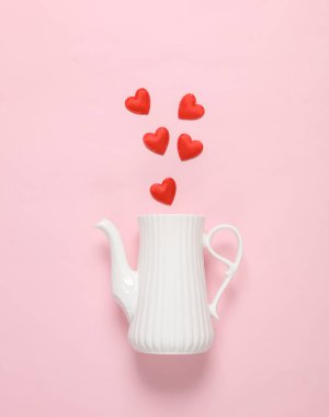 Pembe arka planda kalpleri olan bir çaydanlık. Sevgililer Günü. Yaratıcı yerleşim