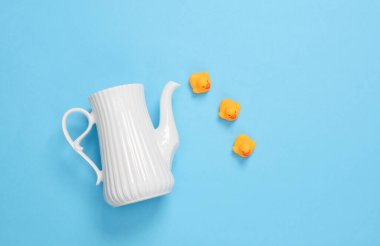 Mavi arka planda lastik ördekli çaydanlık. Yaratıcı yerleşim