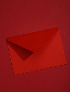 Kırmızı arka planda gölgeli kırmızı bir zarf. Minimalizm tarzı.