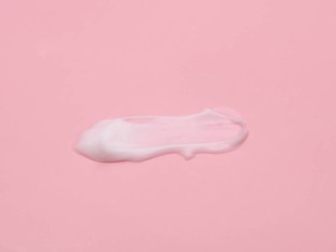 Pembe arka planda sıvı krem kozmetik leke dokusu