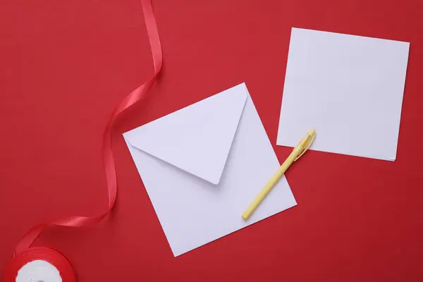 Weißer Umschlag Mit Einem Brief Und Einem Satinband Auf Rotem — Stockfoto