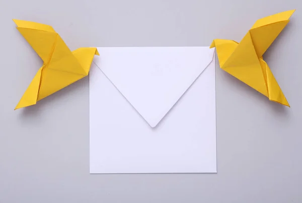 Origami Postduiven Met Een Witte Envelop Een Grijze Achtergrond — Stockfoto