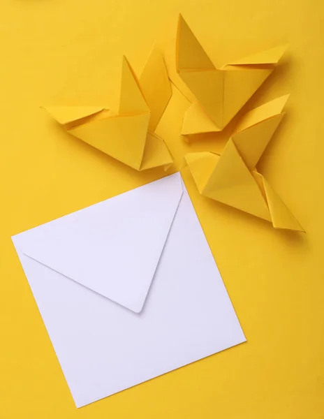 Sarı Zemin Üzerinde Beyaz Bir Zarf Olan Origami Posta Güvercinleri — Stok fotoğraf