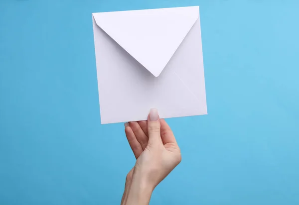 Frauenhand Mit Weißem Umschlag Auf Blauem Hintergrund — Stockfoto