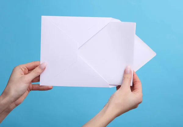 Mãos Mulher Segurando Envelope Branco Com Uma Carta Fundo Azul — Fotografia de Stock