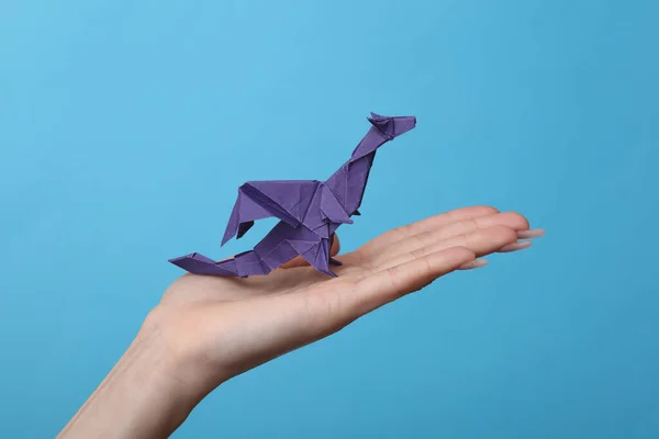 Kvinnliga Handen Håller Origami Dragon Blå Bakgrund Hobby Kreativitet — Stockfoto