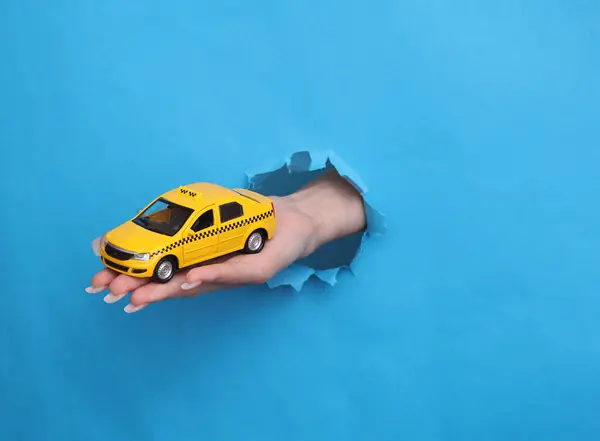 Kadın Oyuncak Taksi Arabasını Yırtık Mavi Kağıt Deliğinde Tutuyor — Stok fotoğraf