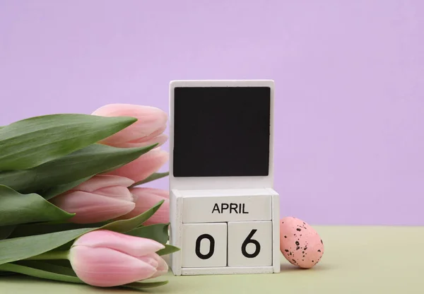 stock image Happy easter. Calendar with date april 06, tulips and easter eggs on pastel background