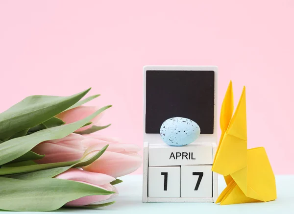 stock image Happy easter. Calendar with date april 17, tulips and easter rabbit with eggs on pastel background