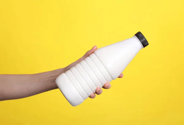 Женщина Держит Бутылку Йогурта Желтом Фоне — стоковое фото