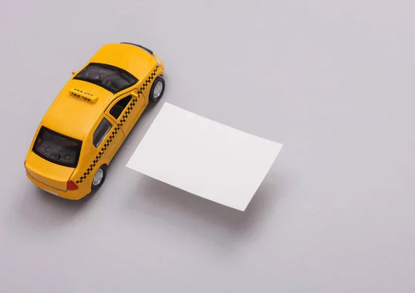 Beyaz Boş Bir Kartvizit Gri Arka Planda Oyuncak Bir Taksi — Stok fotoğraf