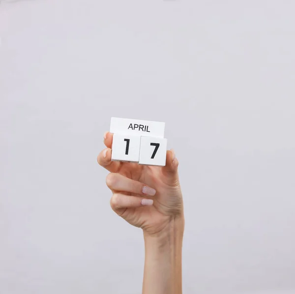 Kalendarz Blokowy Datą Kwietnia Ręku Kobiety Szarym Tle — Zdjęcie stockowe