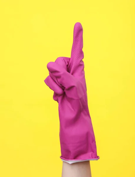 stock image Hand in purple rubber cleaning glove point index finger up on a yellow background. House cleaning and housekeeping concept