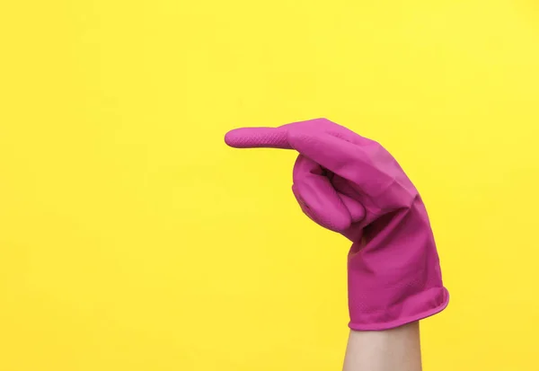 交上紫色橡胶清洗手套 指向侧面的黄色背景 清洁房屋和料理家务的概念 复制空间 — 图库照片