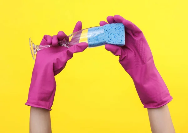 Ręce Gumowych Rękawiczkach Umyć Szklankę Żółtym Tle — Zdjęcie stockowe