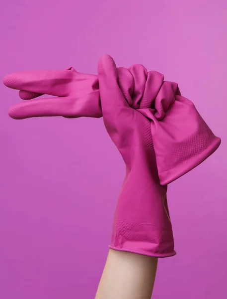 Die Hand Der Frau Hält Gummiputzhandschuhe Auf Lila Hintergrund — Stockfoto