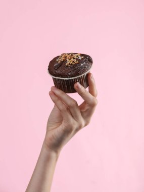 İştah açıcı kek ya da pembe arka planda kadın elinde kek.