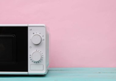 Pembe mavi pastel arka planda modern mikrodalga fırının bir parçası.