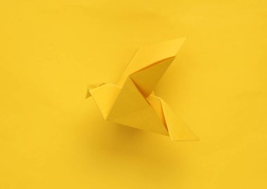 Sarı arkaplanda sarı origami güvercini