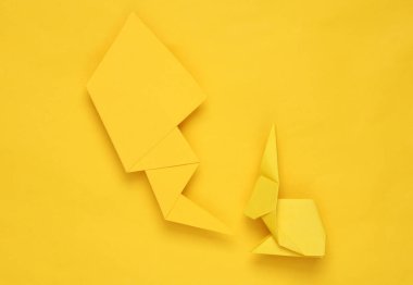 Sarı arkaplanda konuşma balonu olan sarı origami tavşanı