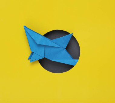 Origami köpekbalığı sarı arka planda bir delikten çıkıyor. yaratıcı yerleşim