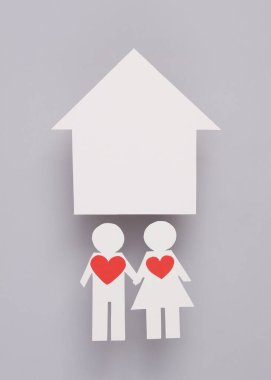 Aşk konsepti. Kağıt kesiği, kalp ve eve aşık bir çift gri arka planda, müşterek mülkiyet