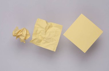 Gri zemin üzerinde kağıt kırışıklığı oluşturan bir topa adım adım